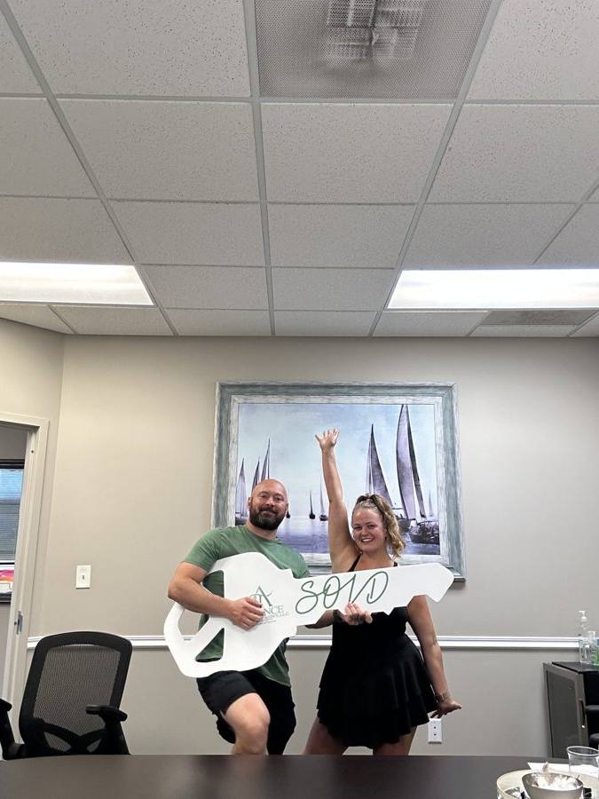 Clients cheering with the oversized SOLD key