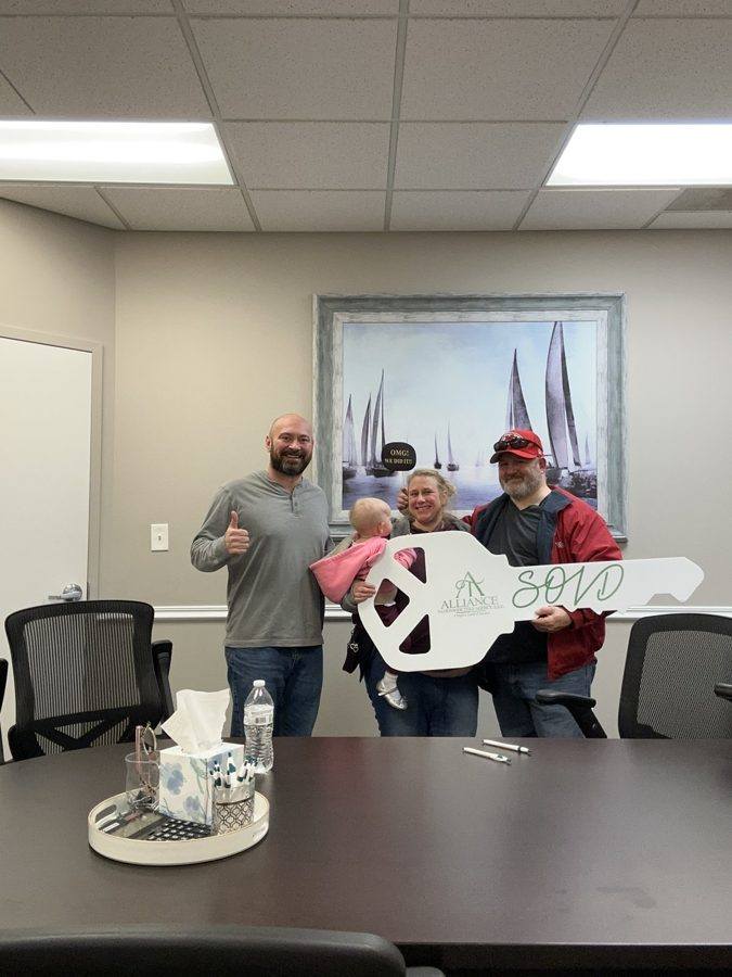 A family celebrating their closing with the SOLD key