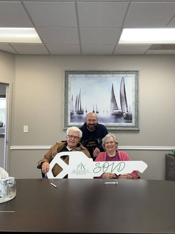An older couple at their closing with the SOLD key